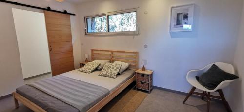 une chambre avec un lit avec une chaise et une fenêtre dans l'établissement Casa FIORI - 2 personnes - Vue mer, à Pietrosella