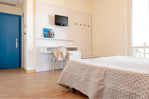 a bedroom with a bed and a tv on the wall at Hotel Oceano in Marina di Pietrasanta