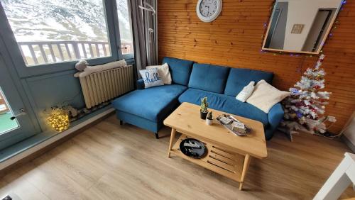 un salon avec un canapé bleu et un sapin de Noël dans l'établissement Appartement 2 chambres vue montagne panoramique, à Bagnères-de-Bigorre