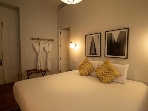 a bedroom with a bed with yellow and white pillows at Villa Barranco by Ananay Hotels in Lima