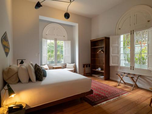 a bedroom with a large white bed and two windows at Villa Barranco by Ananay Hotels in Lima