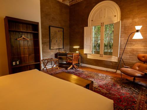 a room with a bed and a desk and a window at Villa Barranco by Ananay Hotels in Lima