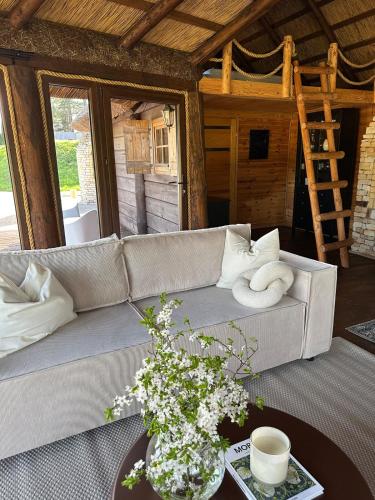 a living room with a couch and a table at Cabin by the pond in Wądołki Bućki