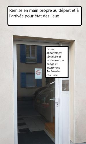 un panneau sur une porte en verre avec un bâtiment derrière lui dans l'établissement Superb apartment, private residence with parking, à Amiens