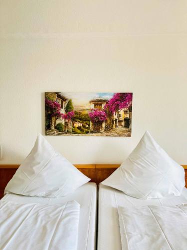 two beds with white sheets and a picture on the wall at Hotel Neo Cologne Bonn Airport in Rösrath