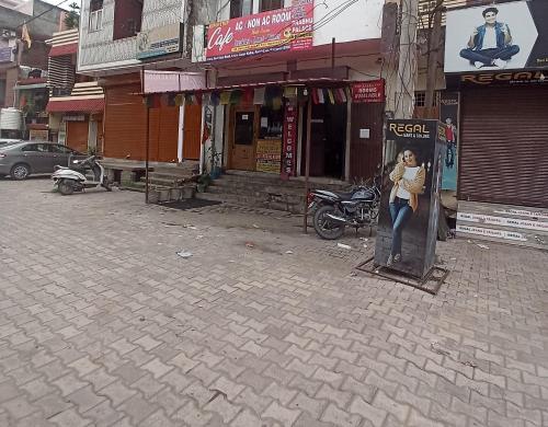 a woman standing in a booth on a city street at Hotel Prabhu in Kālka