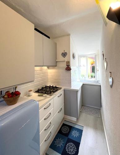 une cuisine avec des armoires blanches et un four à plaques de cuisson dans l'établissement Alloggetto a Chiavari, à Chiavari
