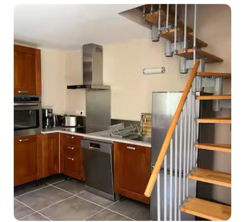 Il comprend une cuisine équipée d'une cuisinière. four supérieur à côté d'un escalier dans l'établissement Petit havre du Brusc de 80 M2, à Six-Fours-les-Plages