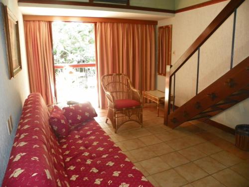 a living room with a couch and a chair and a window at Portal Lençóis in Lençóis