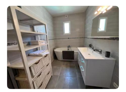 une salle de bain avec une baignoire et un lavabo et une baignoire tubermottermott dans l'établissement Petit havre du Brusc de 80 M2, à Six-Fours-les-Plages