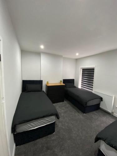 a room with two beds and a desk in it at Cardiff Central Home Sleeps 11 in Cardiff