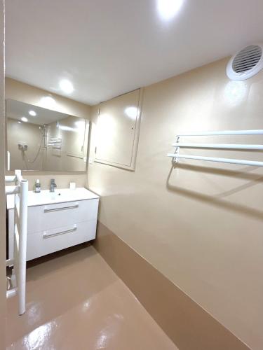 une salle de bain blanche avec un lavabo et un miroir dans l'établissement Maison classée sur le Golfe de St Tropez, à Saint-Tropez