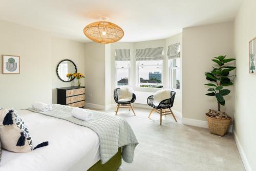 a bedroom with a bed and two chairs and a table at Stunning Townhouse by the sea, Hot Tub sleeps 17 in Seaton