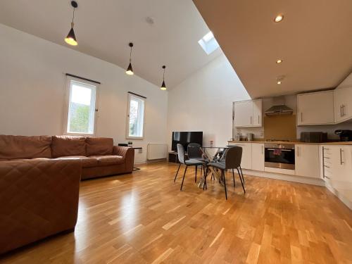 a living room with a couch and a table and chairs at Private Parking 2 Bed 2 bath in Edinburgh