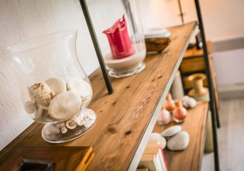 ein Holzregal mit einer Glasvase und anderen Gegenständen darauf in der Unterkunft AIRIAL - Grand Appartement de standing en centre-ville in Soorts-Hossegor