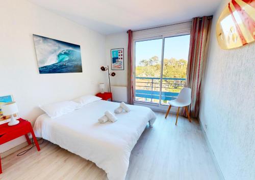 ein Schlafzimmer mit einem Bett und einem großen Fenster in der Unterkunft AIRIAL - Grand Appartement de standing en centre-ville in Soorts-Hossegor