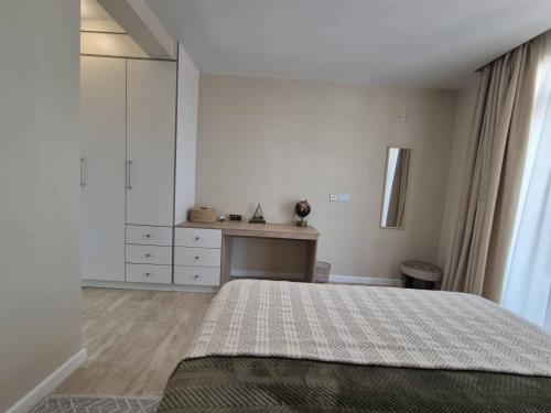 a white bedroom with a bed and a desk at Steady State Kinglands 1 in Lusaka