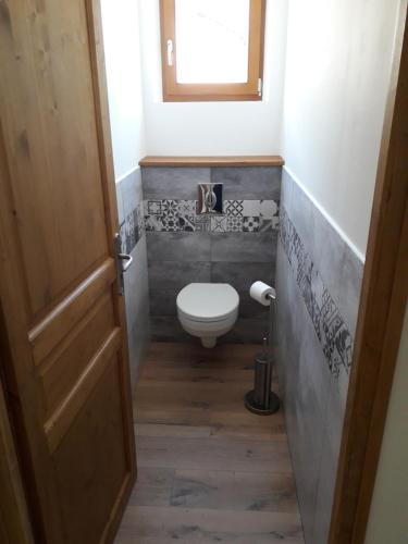 Elle comprend une petite salle de bains pourvue de toilettes et d'une fenêtre. dans l'établissement Appartement avec jardin, au Bourg-dʼOisans