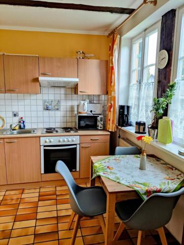 una cucina con un tavolo e sedie in una stanza di Ferienwohnung Pastoriushaus a Bad Windsheim