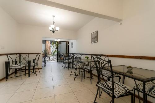 a dining room with tables and chairs in a room at Habitacion triple clasica - Casa Esmeralda in San José