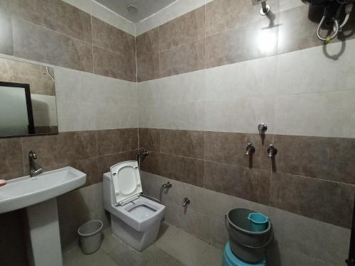 a bathroom with a toilet and a sink at Hotel Prabhu in Kālka