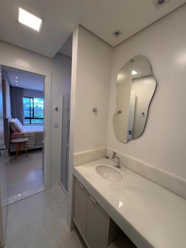 a bathroom with a sink and a mirror on the wall at Cobertura com piscina privativa - Apart hotel in Salvador