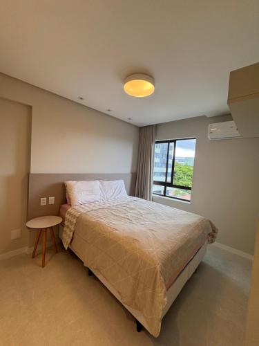 a bedroom with a large bed and a window at Cobertura com piscina privativa - Apart hotel in Salvador