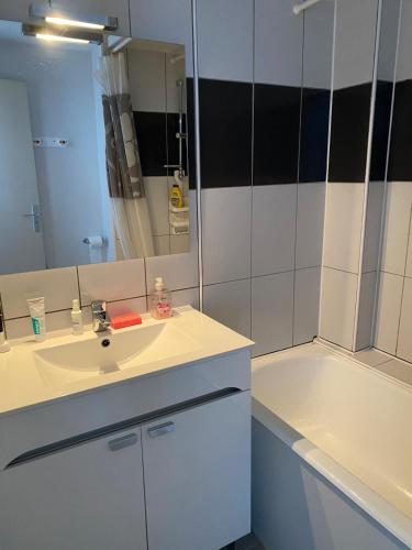 une salle de bain avec un lavabo et une baignoire dans l'établissement Super Lioran T2 dernier étage, à Laveissière