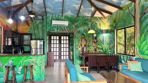 a living room with a tropical mural on the wall at Villa Vista Mar in Dominical
