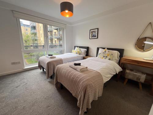 a bedroom with two beds and a window at Apartment 2 bath free parking in Edinburgh