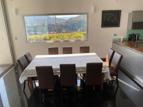 une table et des chaises dans une cuisine avec une fenêtre dans l'établissement Plenitude, à La Celle-sous-Gouzon