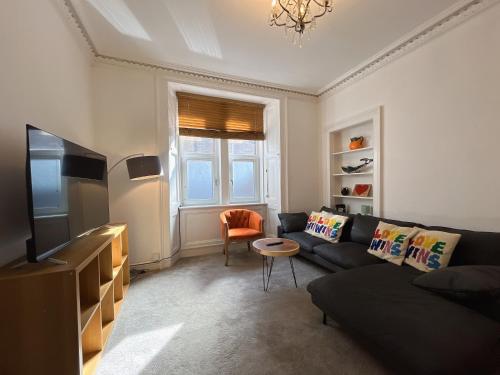 a living room with a couch and a tv at Lovely two bedrooms in Edinburgh