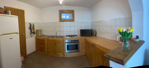 a kitchen with a stove and a vase of flowers at Casa alpin in Izvoru Mureşului