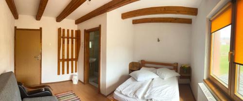a small bedroom with a bed and a window at Casa alpin in Izvoru Mureşului