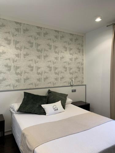 a bedroom with a white bed with a wall at Hotel El Sueño de Jemik in La Roda