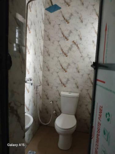 a bathroom with a toilet and a sink at 2bedroom apartment in Agbelekale