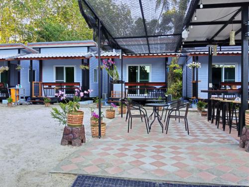 une terrasse avec une table et des chaises ainsi qu'une maison dans l'établissement Mook Raya Resort, à Ko Muk
