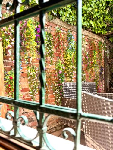 a window view of a garden with flowers on a brick wall at Serenity in Venice