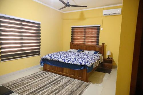 a bedroom with a bed in a yellow room at Huberta Haven in Accra