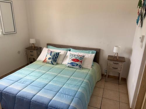 a bedroom with a bed with blue sheets and pillows at Casa vacanze Santiago e Ian in Maruggio