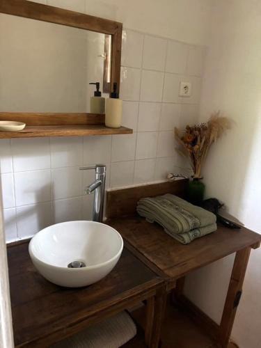 La salle de bains est pourvue d'un lavabo blanc sur un comptoir en bois. dans l'établissement Chambre cosy à 5 min de la plage, à Viagenti