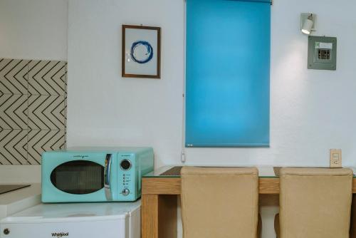a microwave sitting on top of a table with chairs at Petit Bonheur - Calm Intimate - Terrace & Beach in Puerto Vallarta