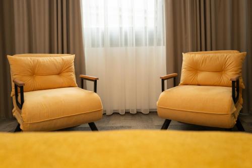 two chairs sitting in front of a window at Hotel MANTOVA Vrhnika in Vrhnika