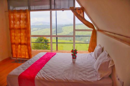 a bedroom with a bed with a large window at Chill mount vagamon in Vagamon