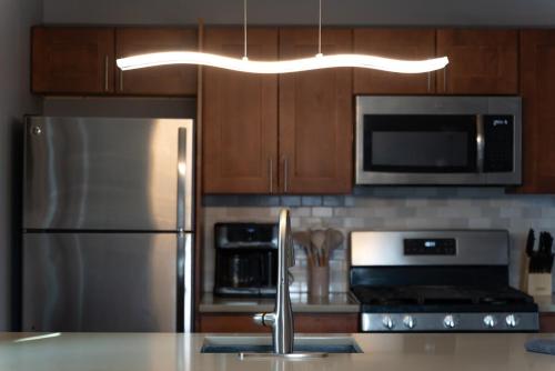 a kitchen with a stainless steel refrigerator and a microwave at Beautiful 2BR Apartment-, Walk To West Point, Free Parking! in Highland Falls