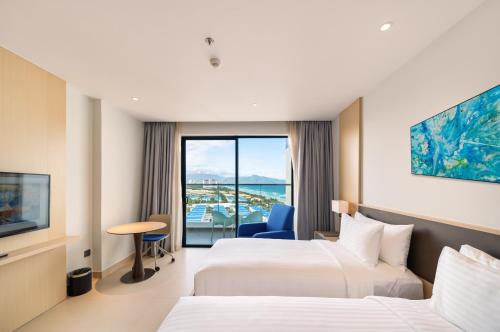 a hotel room with two beds and a window at Arena Cam Ranh Pearl Bay in Cam Ranh