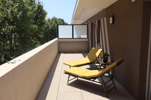 - deux chaises jaunes sur le balcon d'une maison dans l'établissement Le Soleil de Mougins, à Mougins