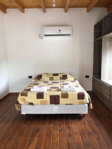 a bedroom with a bed and a wooden floor at Alojamiento en catamarca in San Isidro