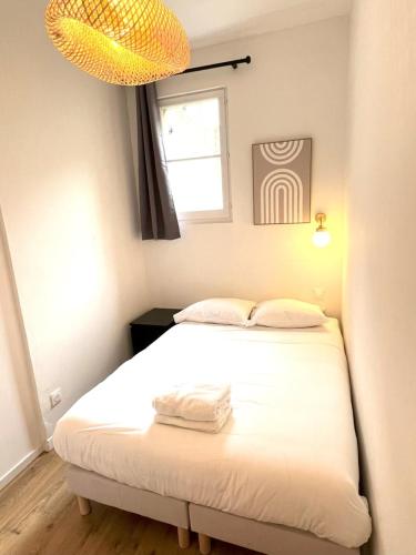 une chambre avec un lit blanc et une fenêtre dans l'établissement LAMENNAIS GAUCHE - T3 rénové en plein centre rennais, à Rennes