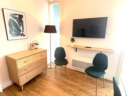 un salon avec deux chaises et une télévision dans l'établissement LAMENNAIS GAUCHE - T3 rénové en plein centre rennais, à Rennes